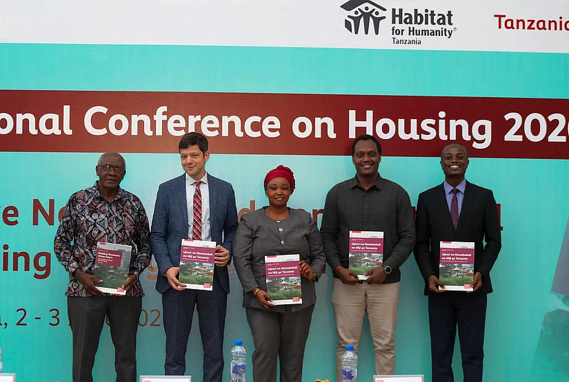 Attendees gather in front of a banner displaying "National Conference on Housing 2026.