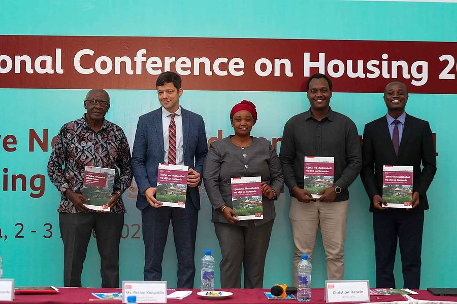 Attendees gather in front of a banner displaying "National Conference on Housing 2026.
