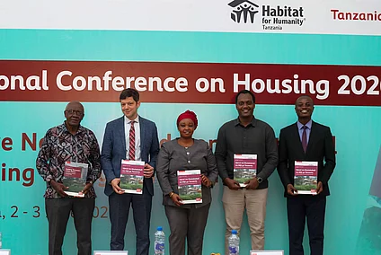 Attendees gather in front of a banner displaying "National Conference on Housing 2026.